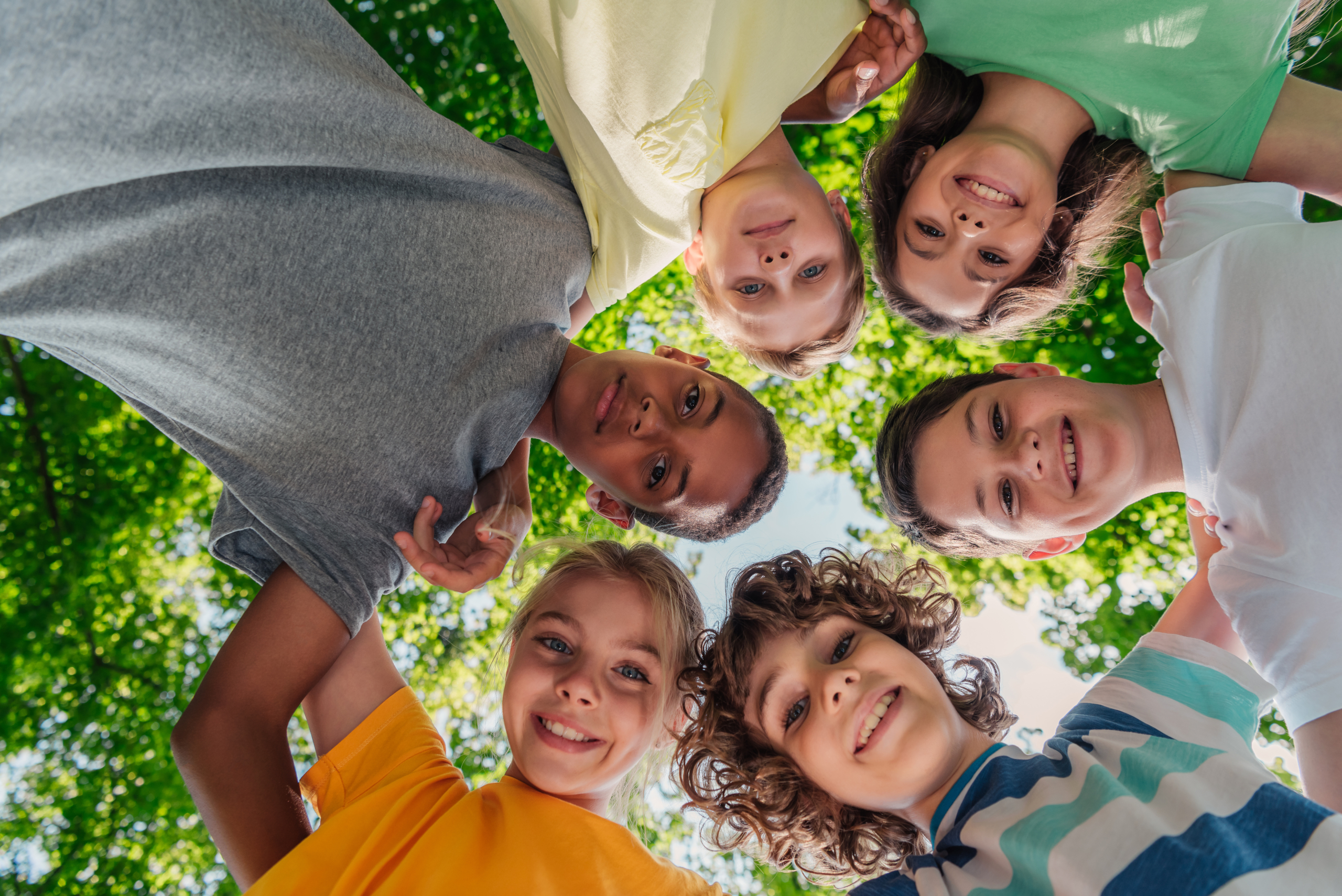 bottom view of happy multicultural children looking at camera